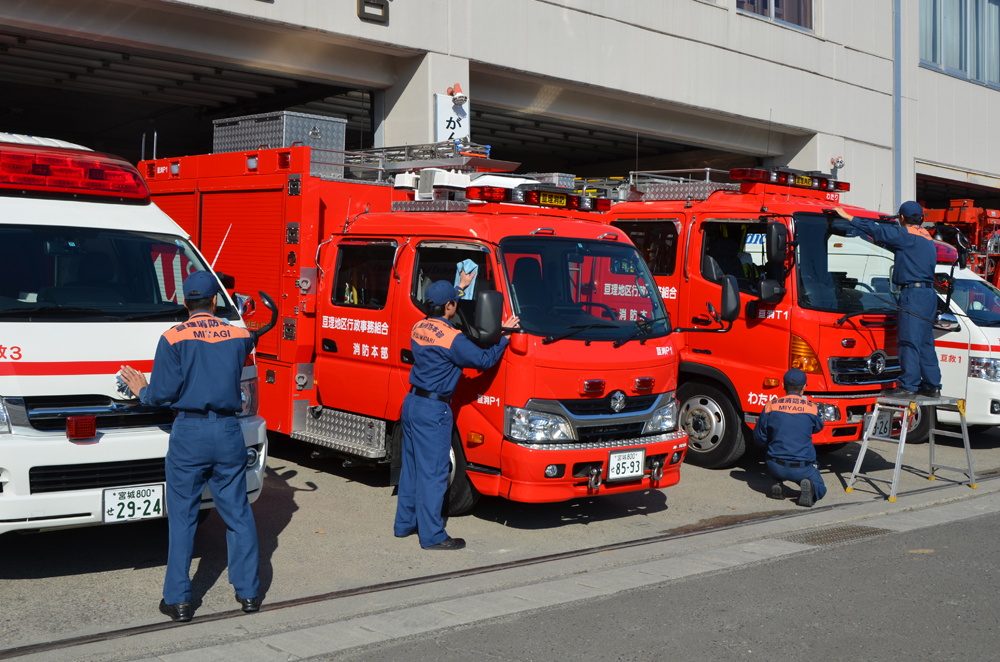 消防車や救急車を綺麗に掃除する消防士達の写真