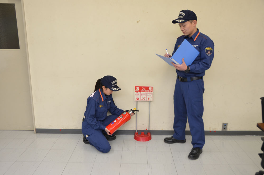 2人で消火器の点検を行う消防士の写真